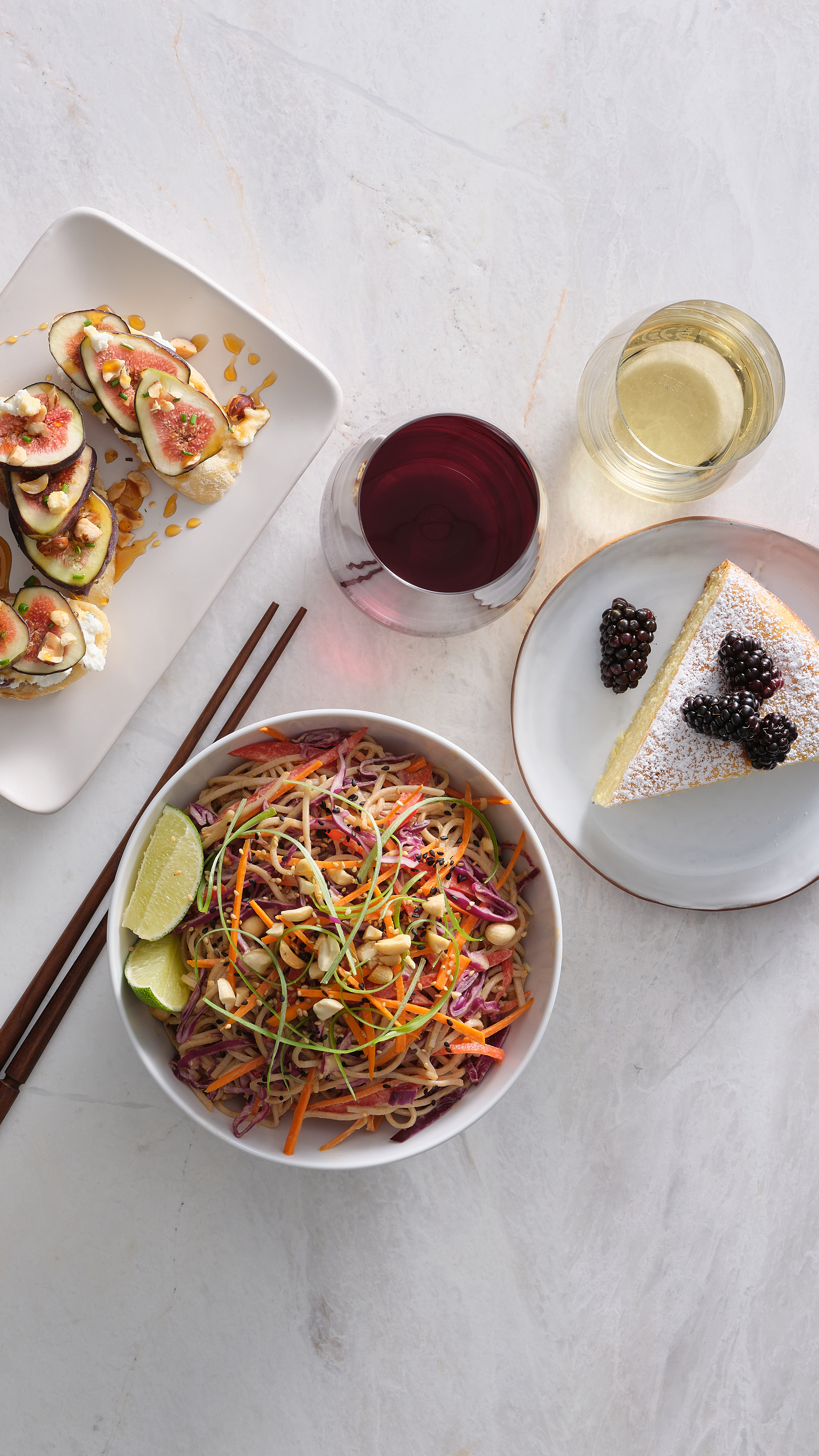 Bruschetta, noodles, and cake with a glass of red and white wine