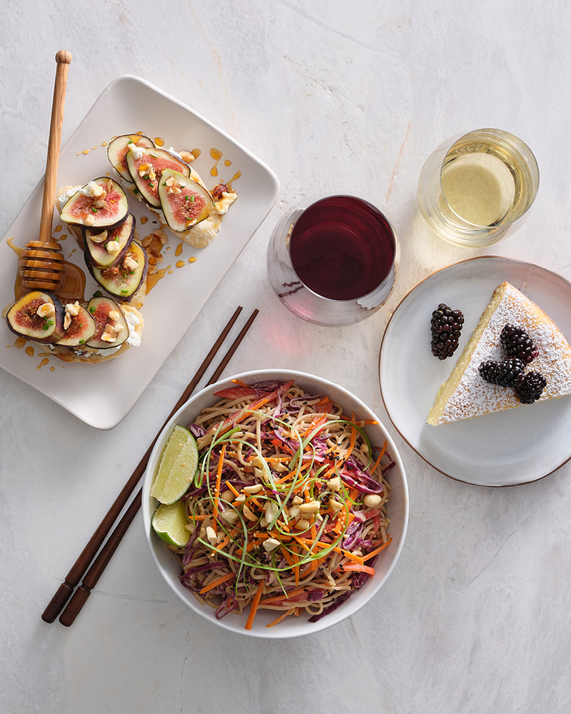 Bruschetta, noodles, and cake with a glass of red and white wine