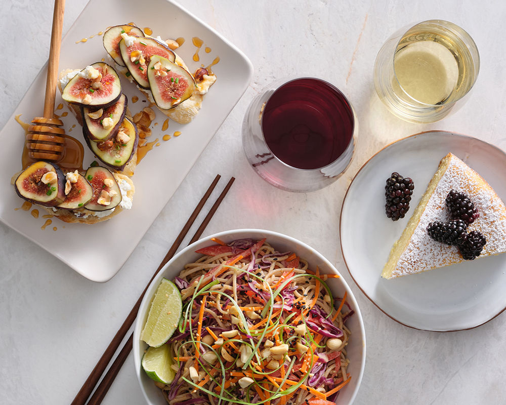 Bruschetta, noodles, and cake with a glass of red and white wine